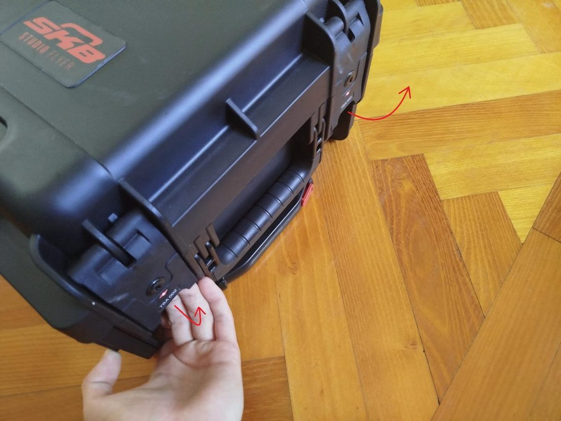 Hand releasing the front latch of the rack