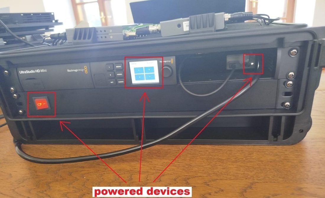 Blue powerCON connector being twist-locked into the rack